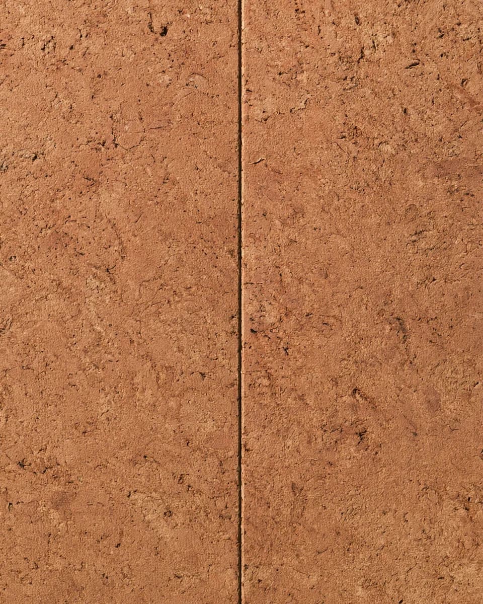 Two cork wall panels meeting at a fine joint, showing the speckled surface